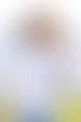 Teenage girl in white t-shirt smiles at her family while posing in front of the Puget Sound at Discovery Park.