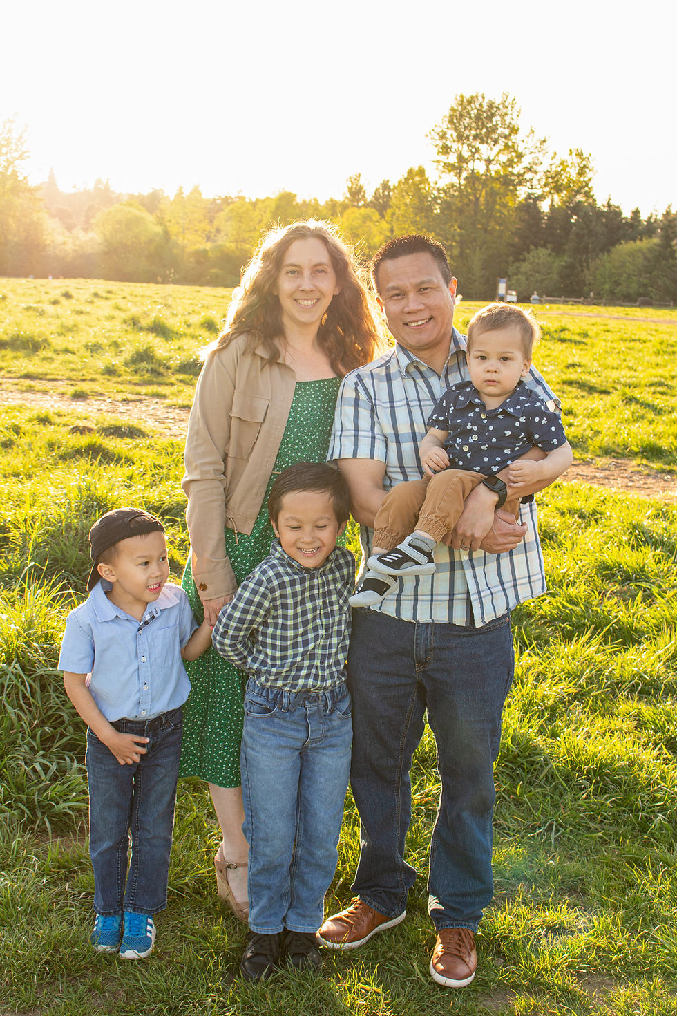 Seattle family in coordinating colors for family portraits in a grassy field