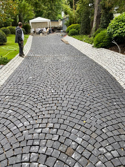 Pose en arc de pavé granit, mouillé, clivé gris foncé et contour gris clair IMGranit