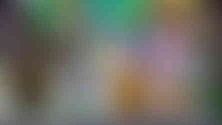 Assorted theme cakes displayed at an exhibition; includes a hamburger, pizza, and designs with vibrant colors. Decor-it and BOSS signs in background.