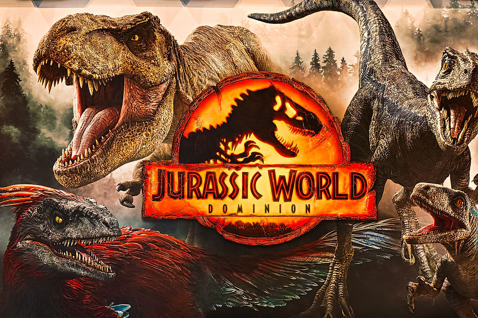 Dinosaurs roar around the "Jurassic World Dominion" logo against a misty forest backdrop. The scene is intense and dynamic.