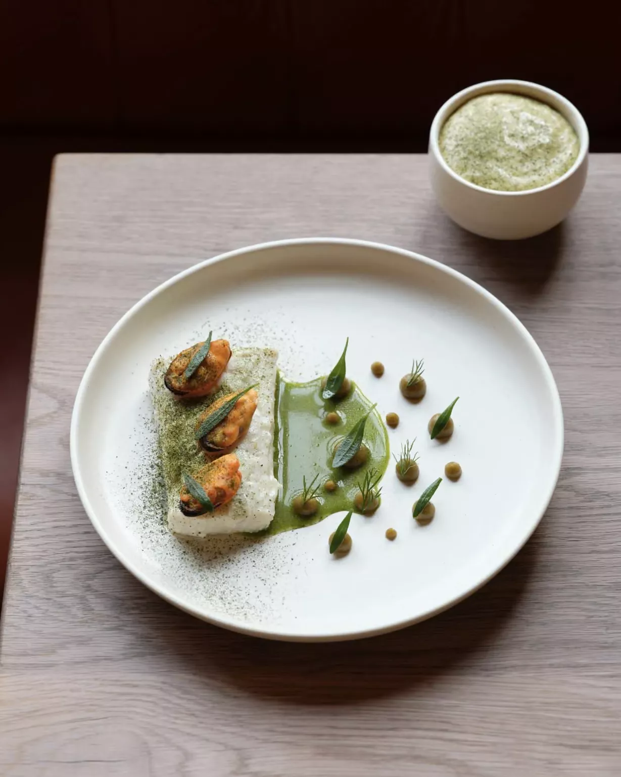 steamed wild halibut, paired with dots of mussel and a foamy green ramekin of potato and seaweed ragu