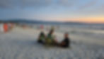 People sat on the beach using portable chairs