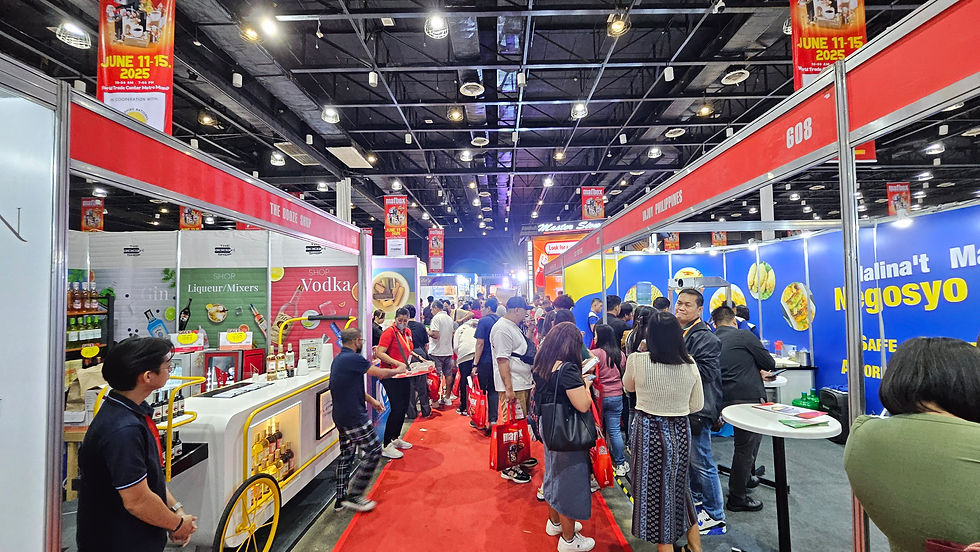 Crowded trade show with red and blue booths, people holding bags, and "June 11-15, 2025" banners. Energetic, busy atmosphere.