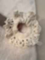 Primrose crochet scrunchie in the hand of a baby