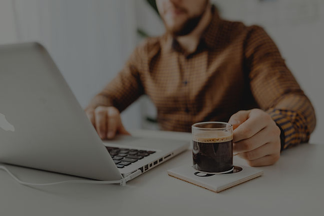 woman working for Olive & Co. Boston Terriers at desk with laptop and coffee
