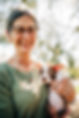 woman holding a boston terrier puppy