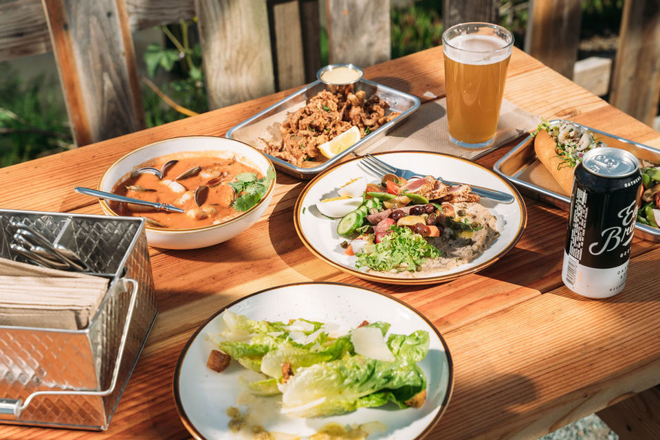 Sailing Goat table with food, salad, beer, seafood stew, chicken, calamari