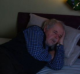 Senior man fell asleep during watching a TV or television at midnight, sleeping concept.jp
