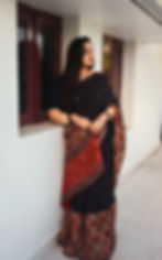 Woman draped in a black Ajrakh print saree with handcrafted ethnic motifs