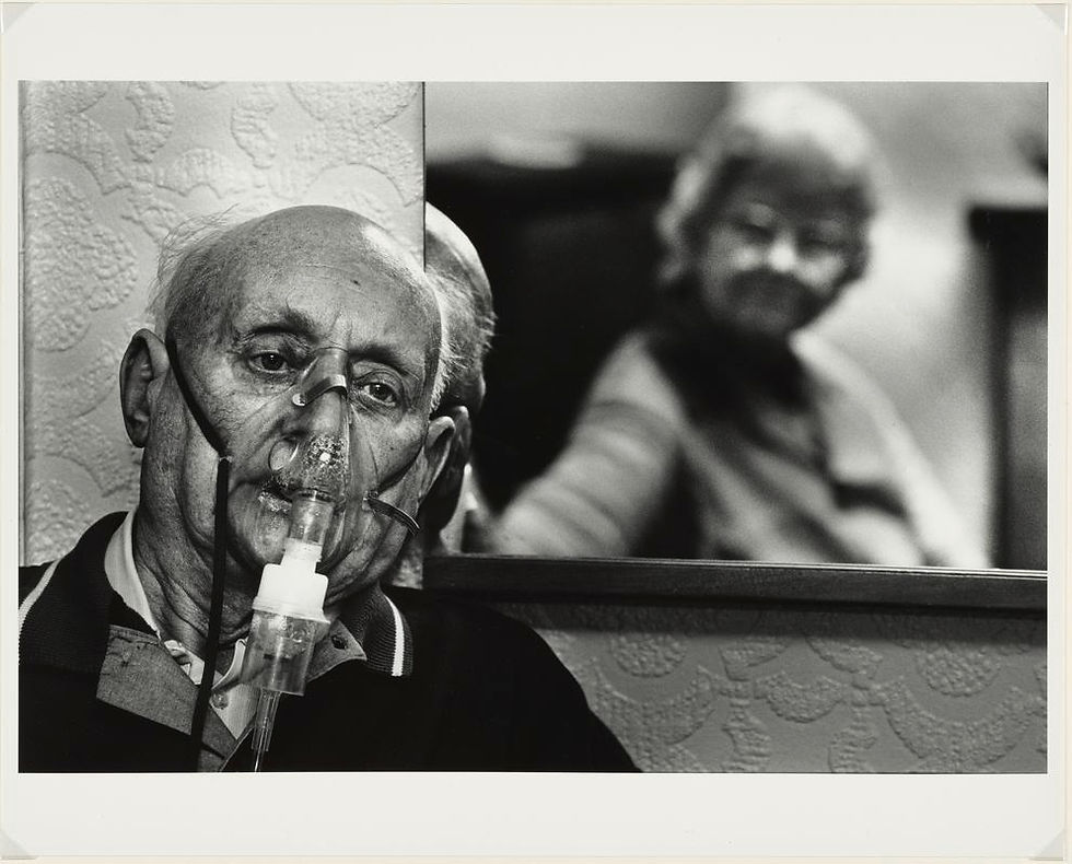 A black and white image of Philip Griffiths, wearing an oxygen mask.
