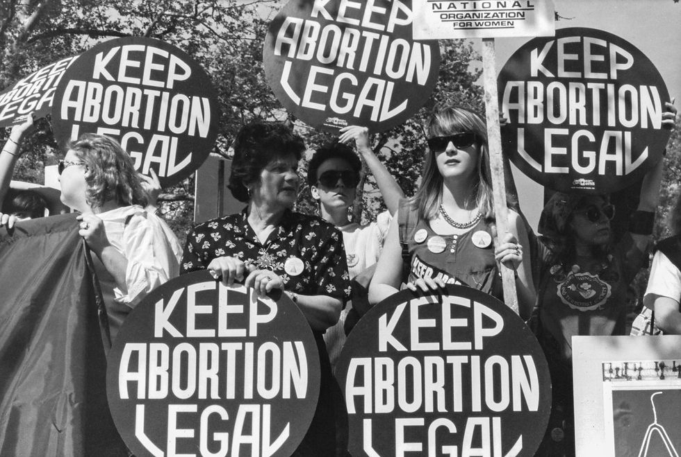 A black and white photograph of a group of protestors holding placards that read 'Keep Abortion Legal'