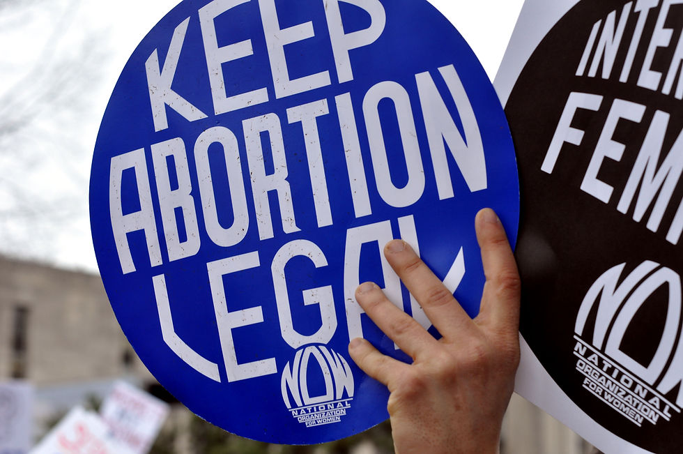 A photograph of a blue placard reading 'Keep Abortion Legal'.