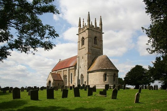 St Andrew’s church, standing in open fields under a cloudy sky, surrounded by its graveyard: all that remains of Robert Mannyng’s Sempringham Abbey.