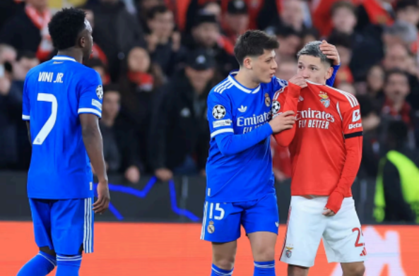 Gianluca Prestianni (à droite) se couvre la bouche en s'adressant à Vinícius Júnior (à gauche) lors du barrage aller de Ligue des champions entre le Benfica et le Real Madrid, le 17 février 2026. Le joueur madrilène a ensuite accusé son adversaire de l’avoir traité de « singe » (Source : Patricia de Melo Moreira / AFP)