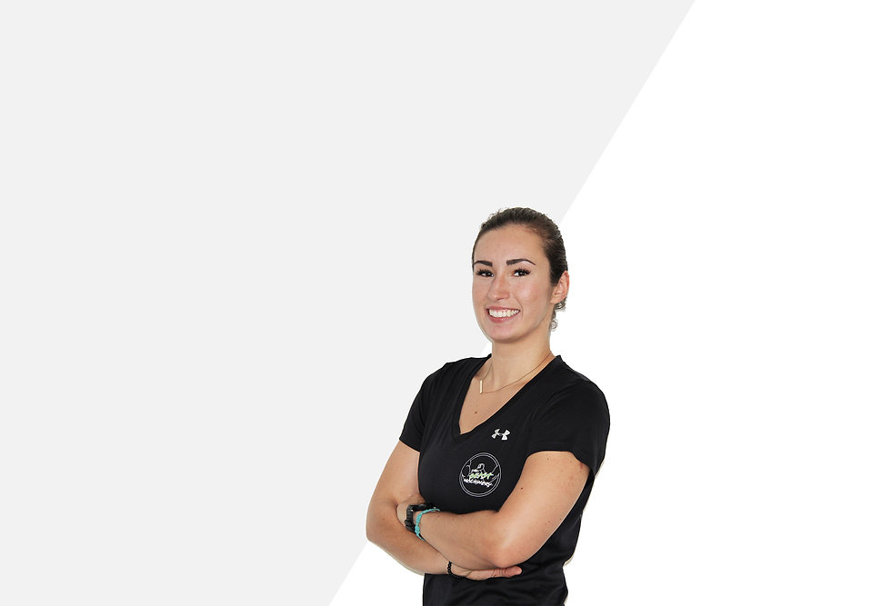 Frau mit dunklen Haaren, breites Lächeln, schaut in die Kamera mit verschränkten Armen. Trägt goldene Halskette, schwarzes Under Armour Shirt mit The Beast Machinery Logo darauf.