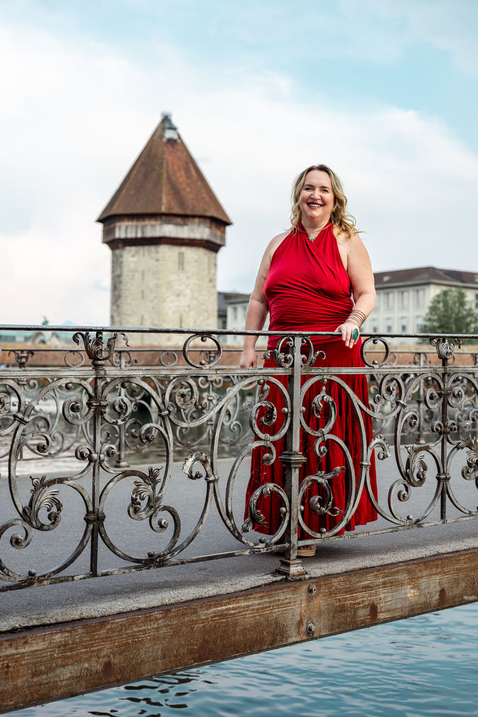lady in red dress with the Chapel bridge in Lucerne in the background