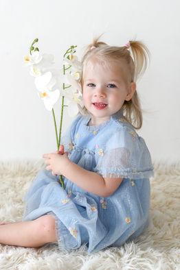 little girl posing with orchids