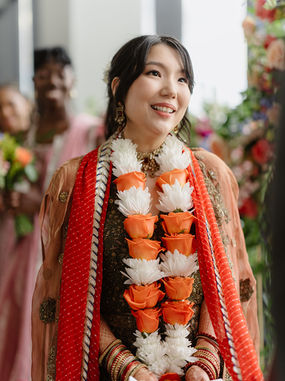 sian bride with soft glam makeup and polished hair standing beside her Indian groom during a luxury stateroom wedding in Boston, captured in warm, elegant lighting.