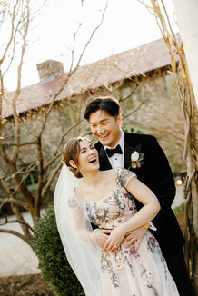 Bride and groom laughing together outdoors after the ceremony with timeless bridal makeup and romantic wedding hairstyle.