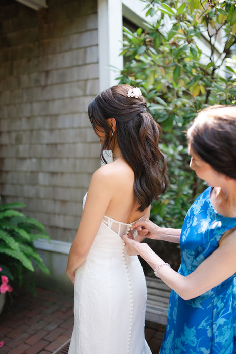 Bride Elaine having her wedding dress buttoned during getting-ready moments at Cape Villa in Wequassett, photographed by Jenna Kay.