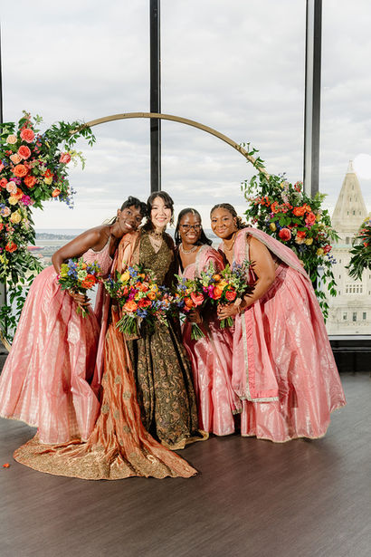 sian bride with soft glam makeup and polished hair standing beside her Indian groom during a luxury stateroom wedding in Boston, captured in warm, elegant lighting.