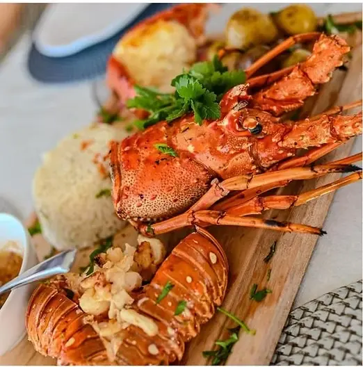 A freshly prepared gourmet seafood lunch featuring lobster and
shrimp served onboard a private Cancun to Isla Mujeres yacht charter.