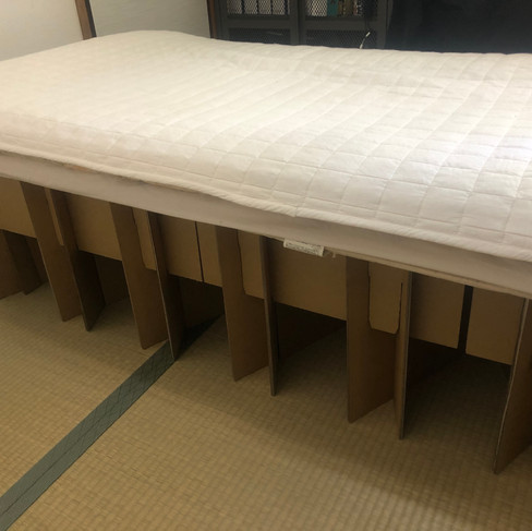 布団を上に敷いた段ボールベッドの写真
