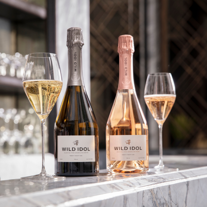 A bottle each of Wild Idol White & rose on a marble bar top with 2 glasses poured