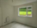 Empty white room with large window and garden view