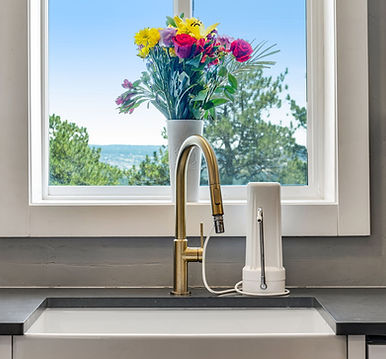 Flower bouquet in front of large kitchen window over the kitchen sink
