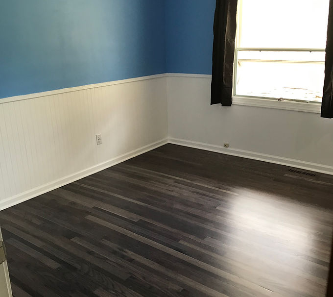 Finished bedroom floor with alternating 1.5" new and 2.25" reclaimed red oak planks, stained dark with iron acetate.