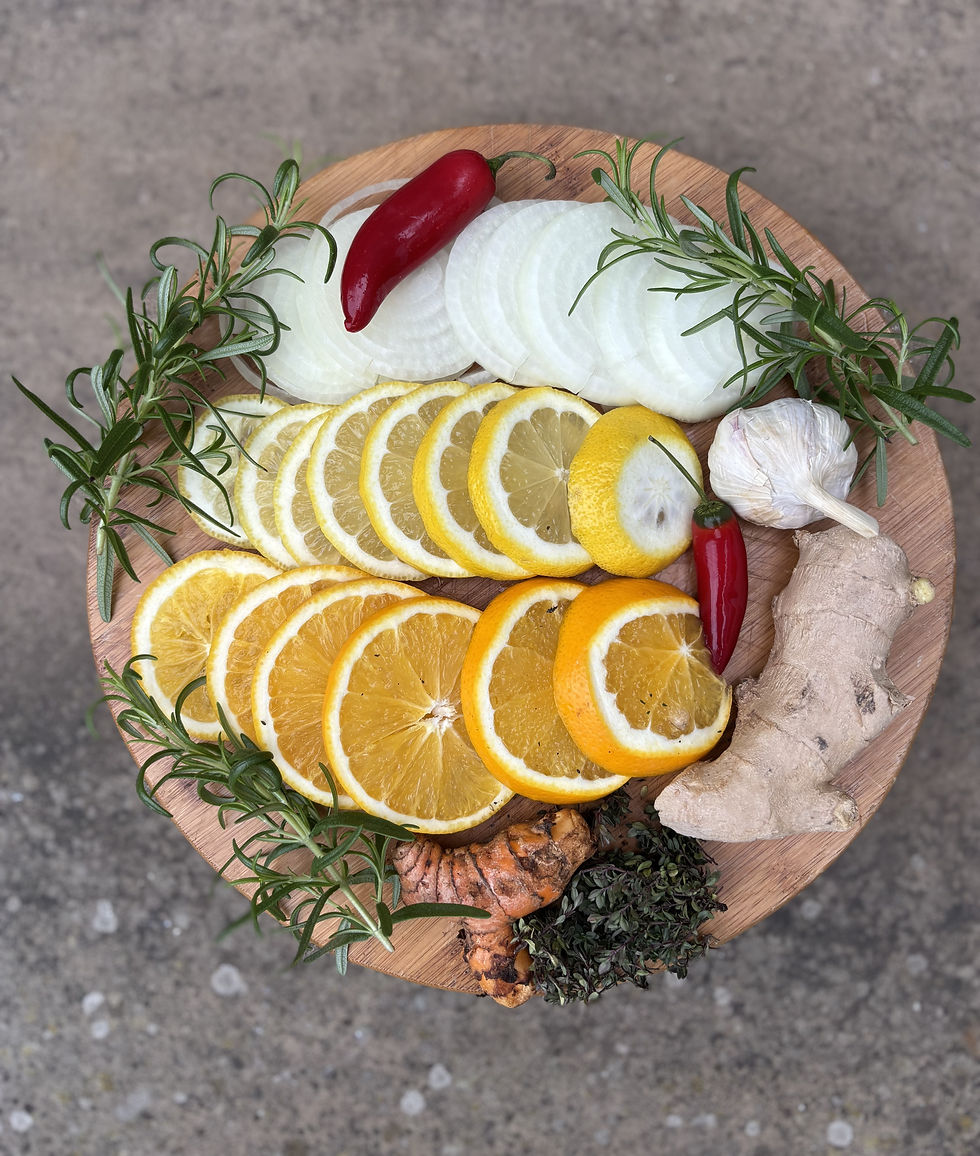 A vibrant collection of fire cider essentials featuring slices of onion, lemon, and orange, accented with rosemary, turmeric, garlic, ginger, and fiery red peppers.