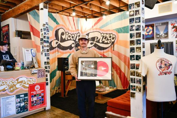 Licorice Pizza Manager, Grant Parsons, displaying a “Midnight Cowgirls” record. (Ari David)