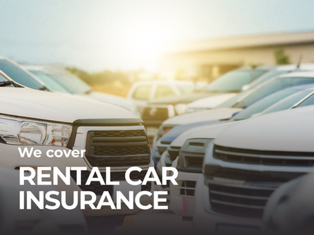 A row of white and black cars are parked outside of a rental car agency.