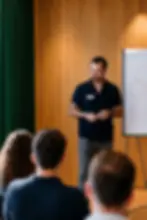 Semih Morel moderiert einen Workshop, am Flipchart drei sich überschneidende Kreise, im Vordergrund Teilnehmende