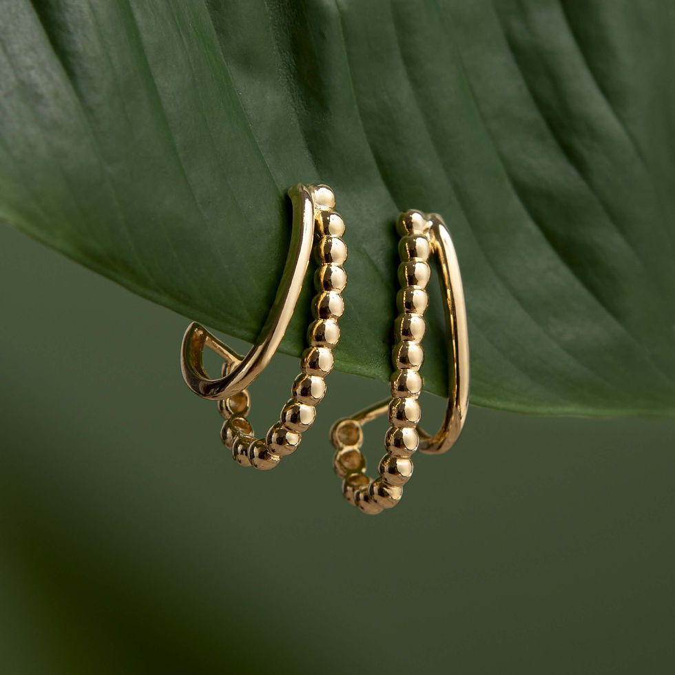 Brinco Ear Hook Duplo Liso e Textura Banhado a Ouro 18k pendurado em folha verde