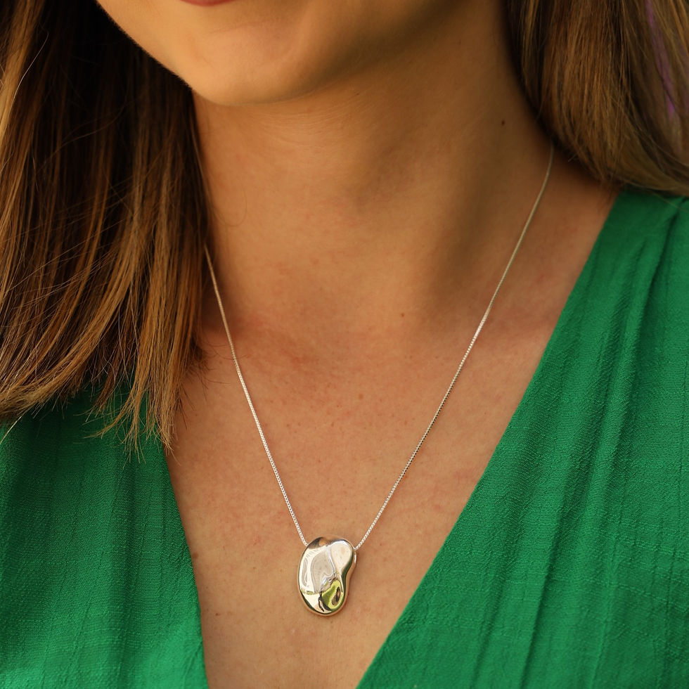 Colar Longo Com Pingente Botão Oval Orgânico Banhado a Prata no pescoço de mulher com roupa verde