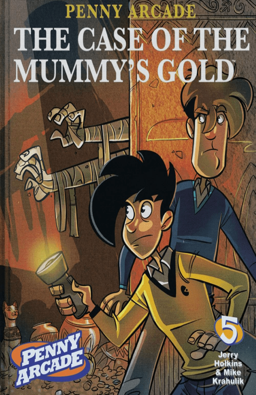 Cover for "Penny Arcade Volume 5: The Case of the Mummy's Gold" featuring the title in stylized letters, over an image of Gabe and Tycho, dressed in the style of the Hardy Boys, exploring a crypt as the hands of a Mummy reach around a nearby corner.