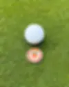 Coinly Peach Ballmarker auf einem Golfgrün