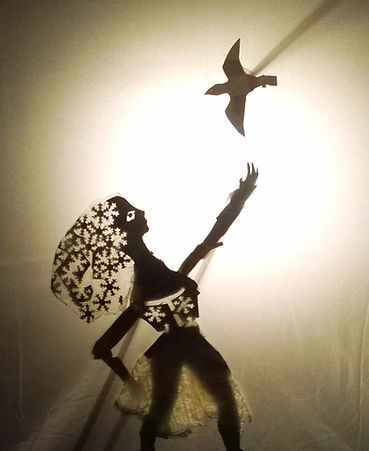 A shadow puppet of a lady and a bird