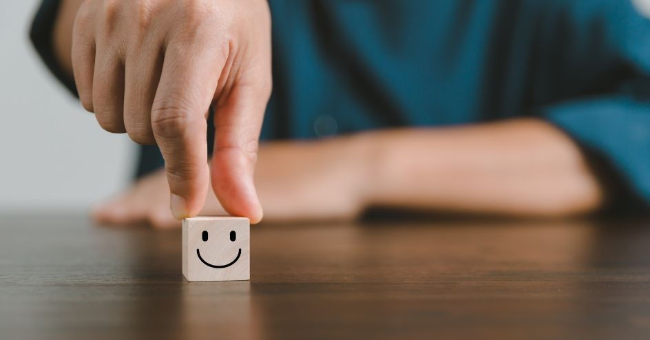 Man setting down smile face dice