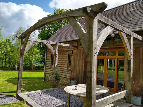 a timber framed pergola designed to match the timber framed barn that had already been built