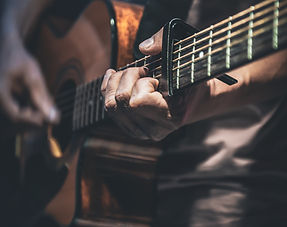 man-plays-acoustic-guitar-closeup.jpg
