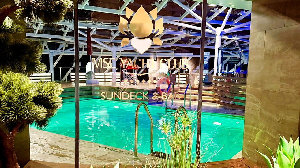 View of a pool at MSC Yacht Club Sundeck & Bar, with glass walls, green plants, and the pool's turquoise water under wooden beams.