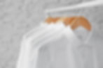 Rack with clean clothes on hangers after dry-cleaning indoors.jpg