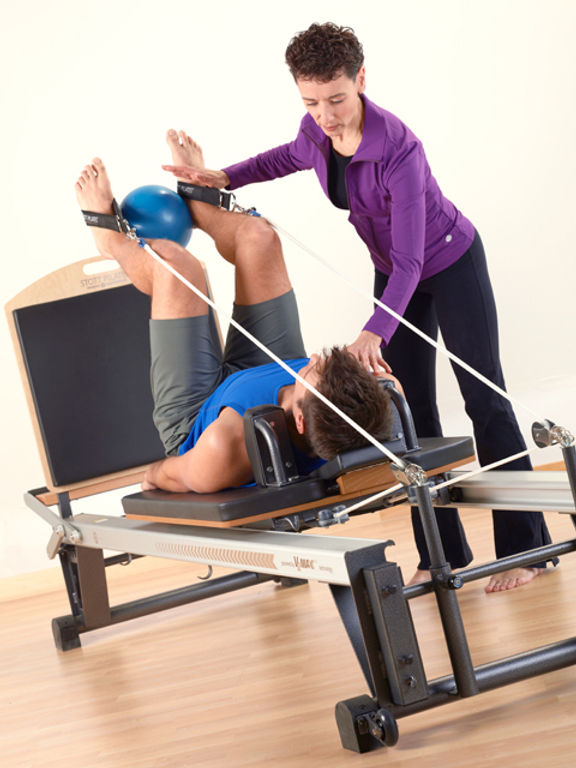 Pilates Instructor assisting a client