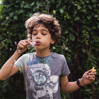 Young boy blowing bubbles outdoors