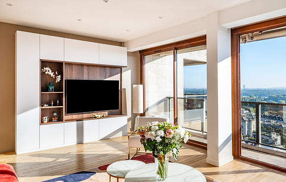Salon rénové à Saint-Cloud, canapé clair et meuble TV contemporain, teintes naturelles et volumes équilibrés.