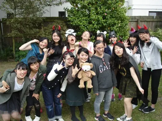 Japanese exchange students enjoying a Halloween event together in New Zealand while wearing fun costumes and accessories.